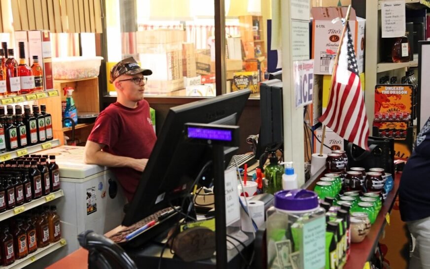 Young man working at a store checkout counter.