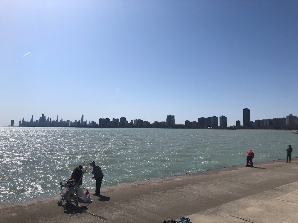 a group of people standing next to a body of water